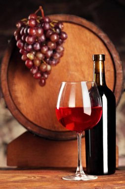 Kırmızı şarap. Cam ve şişe kırmızı şarap ile natürmort. Üzüm ve defocused varil. Seçici odak. Şarap mahzeni atmosfer.