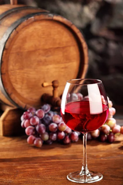 Vino tinto. Vida útil con copa de vino tinto, uvas y barrica. Enfoque selectivo. — Foto de Stock