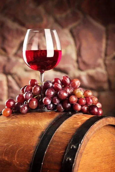 Vino tinto. Vida útil con copa de vino tinto, uvas y barrica. Enfoque selectivo. Ambiente de bodega. Copiar espacio — Foto de Stock