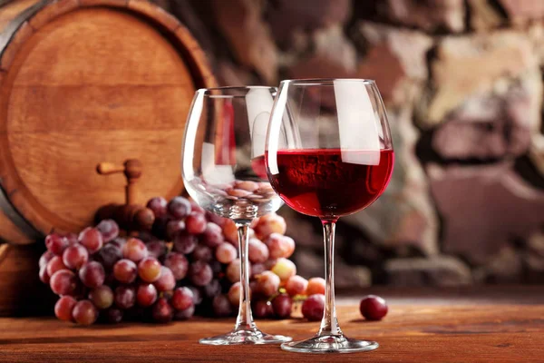 Vino tinto. Vida útil con dos copas vacías y llenas de vino tinto, uvas y barrica. Enfoque selectivo. — Foto de Stock