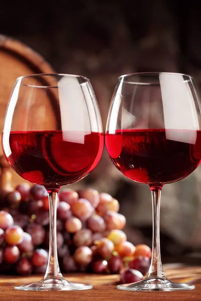 Kırmızı şarap. Closeup iki bardak kırmızı şarap, üzüm ve varil. Seçici odak.