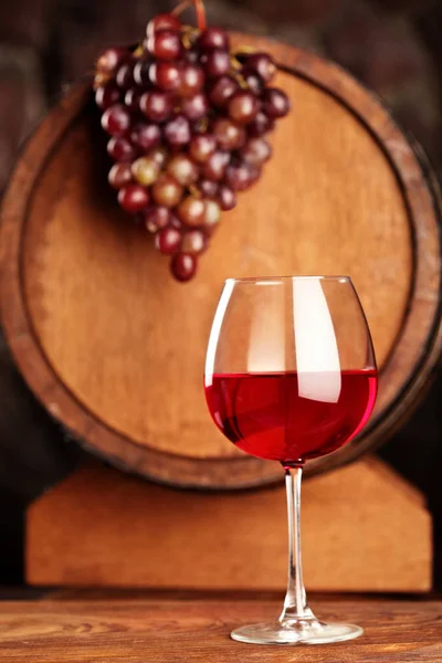 Czerwone wino. Kieliszek czerwonego wina, winogrona i beczki. Selektywny fokus. Miejsce — Zdjęcie stockowe