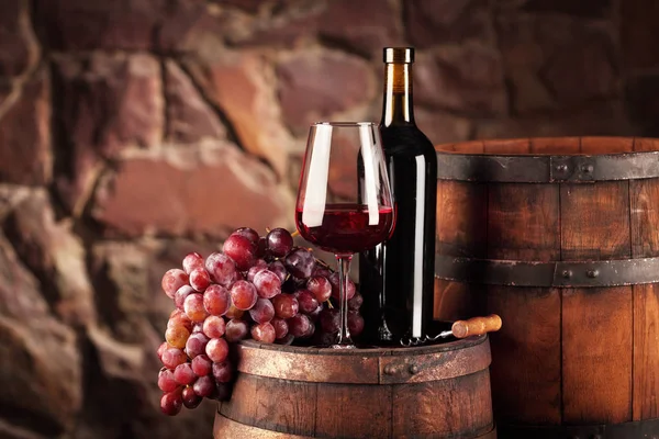 Красное вино. Натюрморт со стаканом и бутылкой красного вина, виноградом и стволом. Лицензионные Стоковые Фото