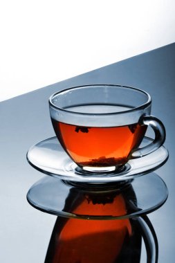 Fincan çay yansıtıcı yüzey üzerinde plaka ile. Yaratıcı yansıması. Degrade arka plan. Kopya alanı