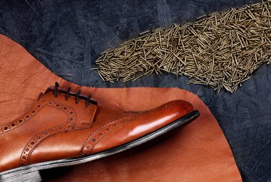 Moda klasik erkek kahverengi oxford brogues deri ve ayakkabı çivileri formunda, koyu ahşap masa emretti parçası üzerinde cilalı. Üstten Görünüm. Kavramı yin ve yang. Yaratıcı