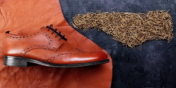 Moda klasik erkek kahverengi oxford brogues deri ve ayakkabı çivileri formunda, koyu ahşap masa emretti parçası üzerinde cilalı. Üstten Görünüm. Kavramı yin ve yang. Yaratıcı