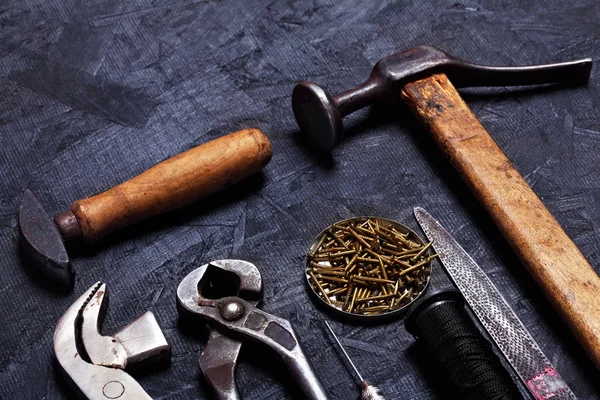 Ayakkabıcı vintage araçları pense, Kerpetenler, dizi kanca dikiş, koyu ahşap arka plan Kundura'nın çekiç. Üstten Görünüm