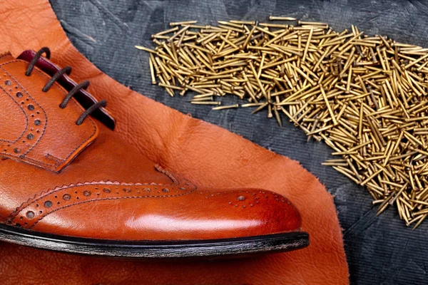 Moda klasik erkek kahverengi oxford brogues deri ve ayakkabı çivileri formunda, koyu ahşap masa emretti parçası üzerinde cilalı. Üstten Görünüm. Kavramı yin ve yang. Yaratıcı