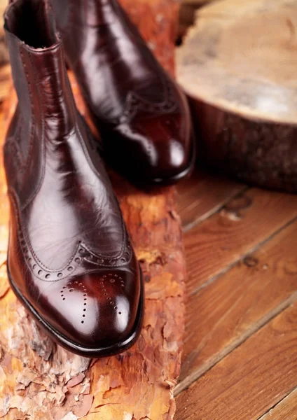 Botas de cuero marrón chelsea pulidas sobre tabla de pino. Botas de depilación.Copiar el espacio . — Foto de Stock