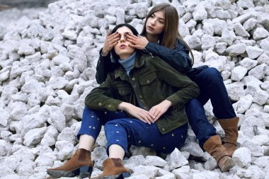 Ay yüzeyinde iki güzel kız sit. Diğer kız yakın gözler