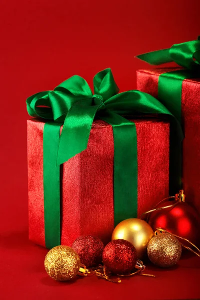 Caixas de presente vermelho com fitas verdes e arco com bolas de Natal dourado no fundo feriado vermelho. Feliz cartão de Natal. Inverno xmas theme.Boxing dia — Fotografia de Stock