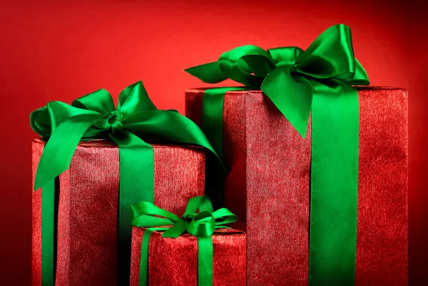 Caixas de presente vermelho com fitas verdes e arco em fundo feriado vermelho. Feliz cartão de Natal. Inverno xmas theme.Boxing day.Closeup — Fotografia de Stock