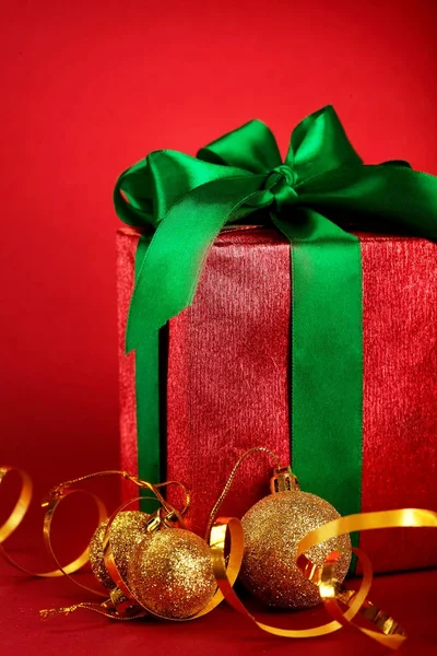 Caixas de presente vermelho com fitas verdes e arco com bolas de Natal dourado no fundo feriado vermelho. Feliz cartão de Natal. Inverno xmas theme.Boxing dia — Fotografia de Stock