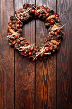 Noel çelenk çelenk meşe palamutları ve koniler ve köpek ahşap arka plan üzerinde yükseldi. Uzay kopyalayın. Noel arka plan