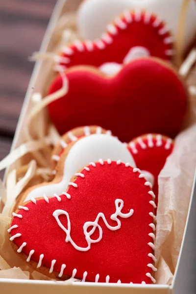 Red cookies hearts with white icing Love in white box .Gift for Valentine\'s Day.Valentine day background.Closeup