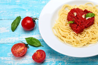 Spagetti, Pasta.Toamtoes sosu kalp şekli. Fesleğen, domates, sarımsak, deniz tuzu, karabiber. Camgöbeği ahşap arka plan. Sevgililer günü. Kavram aşk. Kopya alanı