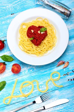 Spagetti, Pasta.Toamtoes sosu kalp şekli. Fesleğen, domates, sarımsak, deniz tuzu, karabiber. Insrption aşk Spaghetti.Food Typography'nin. Camgöbeği ahşap arka plan. Sevgililer günü. Kavram aşk