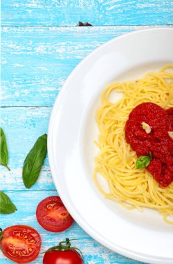 Spaghetti, Pasta.Toamtoes sauce i shape heart.Basil, tomatoes, garlic, sea salt, pepper.Cyan wooden background.Valentine day.Concept love.Copy space clipart