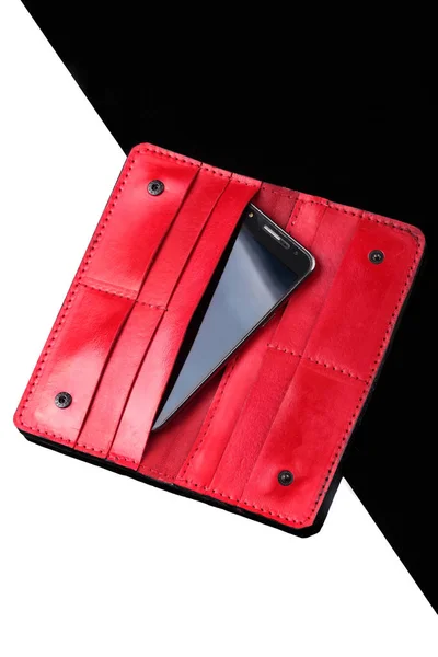Відкритий довгий гаманець чорної шкіри крокодила та червоної шкіри з смартфонами всередині. Розкішний гаманець. Чорно-білий фон — стокове фото
