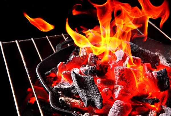 Burning charcoal.With Bright Flame.In cast iron grill frying pan.Cocnept barbecue Grill.On The Black Background.Copy space — Stock Photo, Image