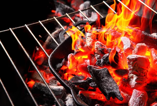 Égő faszén. Bright Flame.In öntöttvas grill serpenyő. Cocnept grillező hely Grill.On a fekete Background.Copy — Stock Fotó