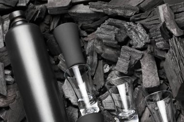 Mat şişe alkol ve atış gözlük siyah kümesi. Kömür arka plan üzerinde. Siyah baskı. Yaratıcı. içelim. Cheers.Mockup.Creative arka cam ve kömür