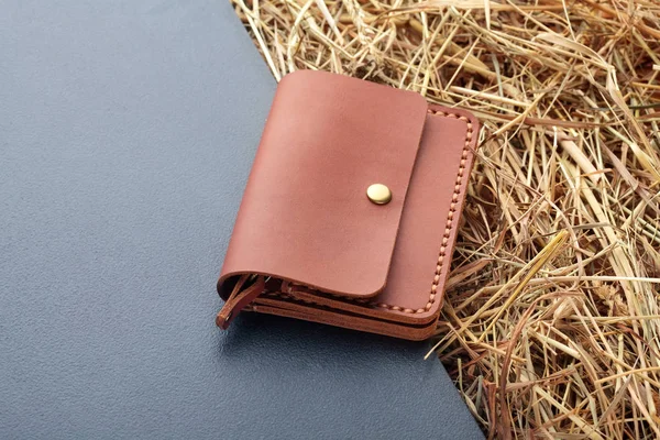 Hand made brown leather man wallet . Multi colored. Leather craft.On dark background.Top view