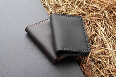 İki kahverengi kümesi ve ve siyah kart sahibi. El yapımı deri adam kart sahibi. Çok renkli. Deri el sanatları. Yaratıcı zemin üzerine. Üstten Görünüm