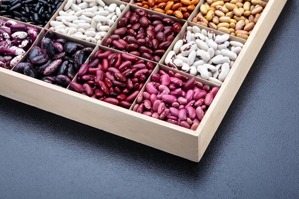 Diferentes tipos de legumes feijões. Em caixa de madeira.Variedades de beans.Top view.Closeup.Texture.Copy espaço. — Fotografia de Stock