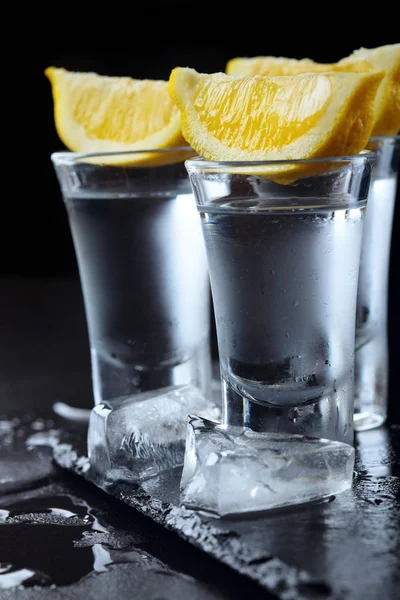 Vodka. Colpi, bicchieri con vodka con limone.Scuro sfondo di pietra.Copia spazio .Prima.Focus selettivo — Foto Stock