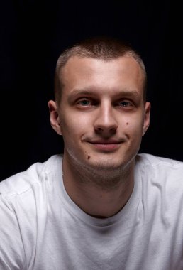 Yakışıklı beyaz delikanlı. Beyaz t-shirt. Smile.Emotion. siyah arka plan üzerine. Portre