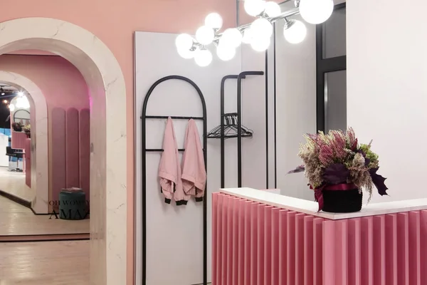 Interiör av lyxig snygg skönhetssalong. Mottagning av skönhetssalong och galge med speciell rosa jacka på hanger.Pink koncept design. — Stockfoto