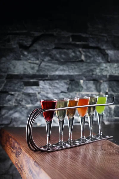 Bunte Alkoholische Cocktails Schnapsgläsern Auf Holztisch Und Steinwand — Stockfoto