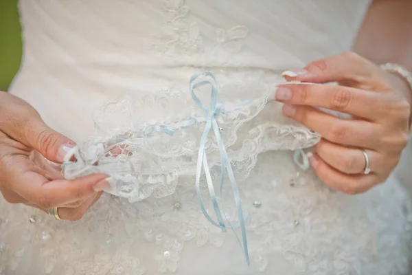 Eine Braut mit Strumpfbandhänden. zieht die Braut das Strumpfband aus Spitze. Attribut Braut. — Stockfoto