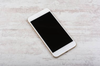 Beyaz ahşap zemin üzerinde modern dokunmatik ekran akıllı telefon