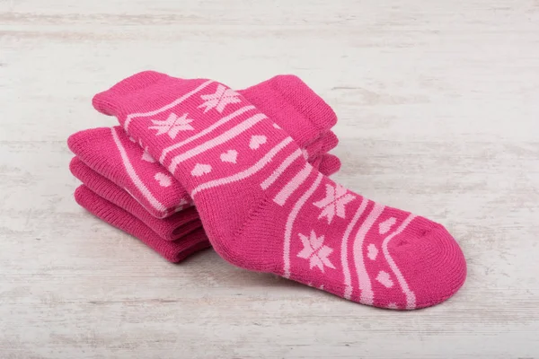 Розовые шерстяные носки на белом деревянном фоне — стоковое фото
