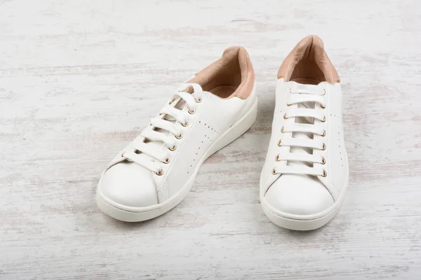 Жіноче спортивне взуття на білому дерев'яному фоні — стокове фото