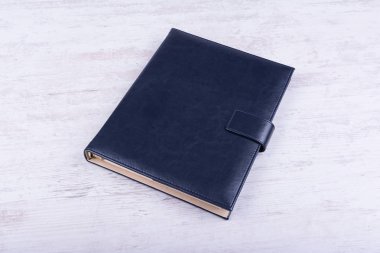Beyaz ahşap zemin üzerinde mavi deri notebook