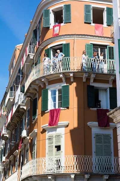 Corfu, Yunanistan - 30 Nisan 2016: Binalar ile Kutsal Cumartesi sabahı diriliş beklentisiyle balkonlarda kırmızı bayrak. Paskalya pot Smashing.