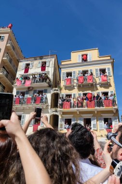 Corfu, Yunanistan - 30 Nisan 2016: Corfians kil tencere windows ve balkon Kutsal İsa'nın diriliş kutlamak için Cumartesi günü at. Paskalya pot Smashing.