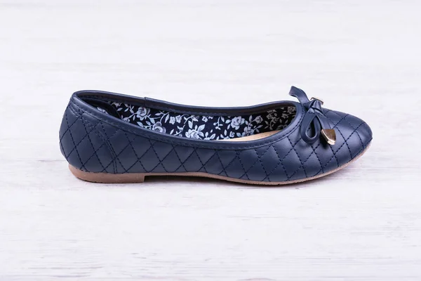 Темно-синє жіноче пласке взуття на білому дерев'яному фоні . — стокове фото