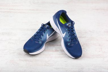Burgas, Bulgaristan - 6 Eylül 2017: Nike Air Zoom Pegasus 34 kadın koşu ayakkabıları mavi beyaz ahşap zemin üzerinde. Nike global spor giyim ve spor ayakkabısı perakendeci olduğunu.