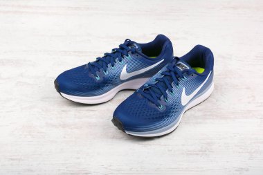 Burgas, Bulgaristan - 6 Eylül 2017: Nike Air Zoom Pegasus 34 kadın koşu ayakkabıları mavi beyaz ahşap zemin üzerinde. Nike global spor giyim ve spor ayakkabısı perakendeci olduğunu.