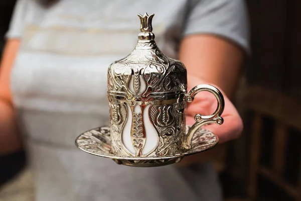 Frau serviert türkischen Kaffee in einer traditionellen silbernen Tasse. — Stockfoto