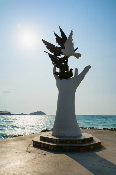 Kuşadası, Türkiye - 22 Ağustos 2017: Barış heykel Kuşadası, Türkiye'de sahildeki güvercinler ile el. — Stok fotoğraf