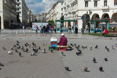 Thessaloniki, Yunanistan - 29 Mayıs 2017: Ünlü Aristotelous square, Thessaloniki, Yunanistan. Güvercin besleme için tohum satan kadın. Thessaloniki Yunanistan'ikinci büyük şehridir