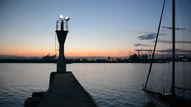 ポート ブルガス ブルガリアの黒海の夕暮れの灯台 夕暮れ時のクレーンのシルエット — ストック動画