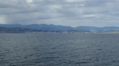 Güzel deniz manzarası ile turkuaz suların İyon Denizi temizleyin. Mavi lagün plaj sahil, Kassiopi, Corfu Island, Yunanistan. Karanlık fırtınalı bulutlar ile doğal arka plan.