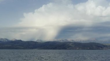 Güzel deniz manzarası ile turkuaz suların İyon Denizi temizleyin. Mavi lagün plaj sahil, Kassiopi, Corfu Island, Yunanistan. Karanlık fırtınalı bulutlar ile doğal arka plan.