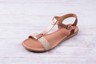 Beyaz ahşap zemin üzerinde kadın sandalet